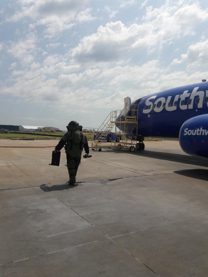 Bomb Squad member in full gear walking towards a Southwest Airlines airplane