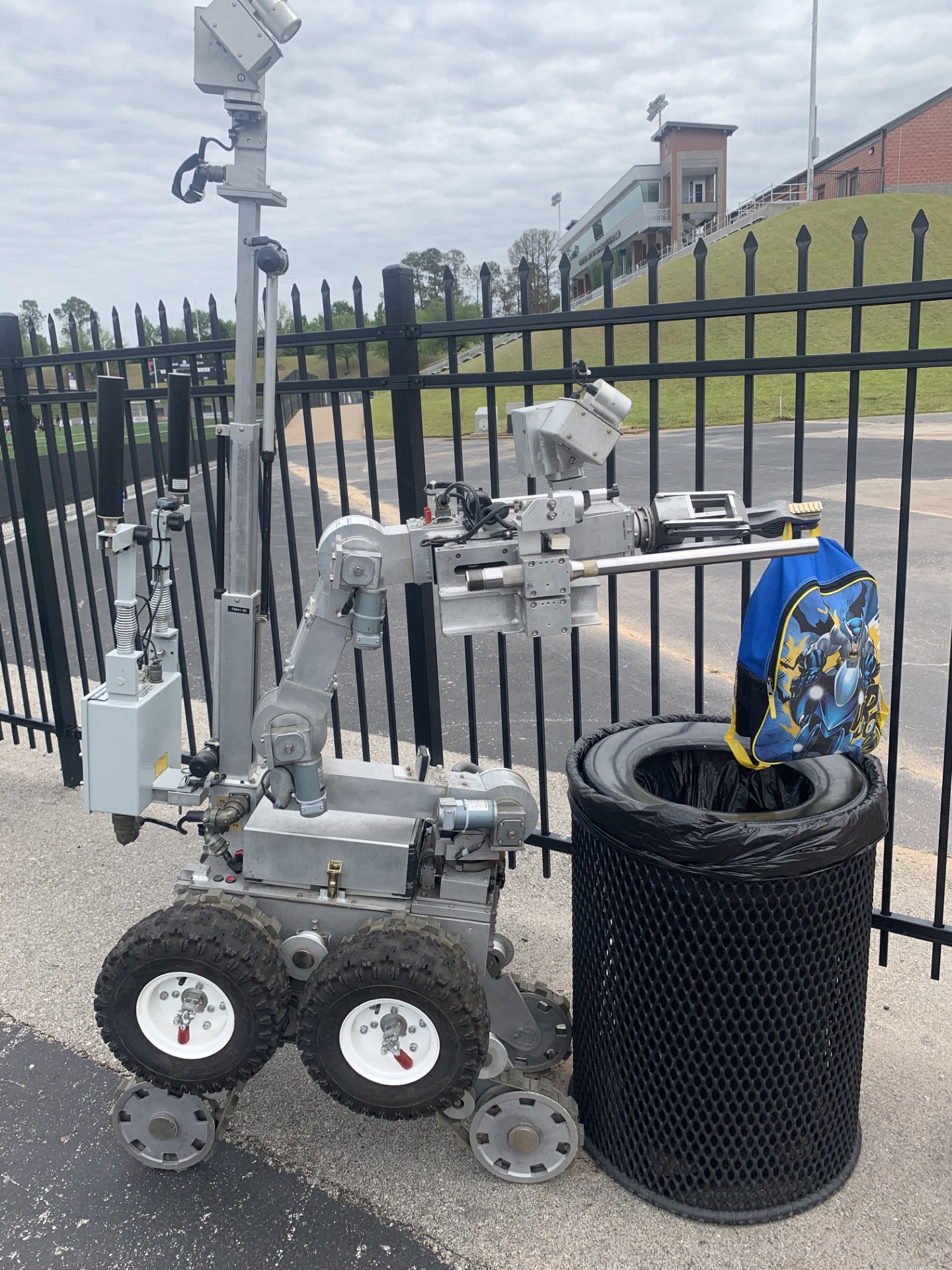Bomb Squad robot handling a children's backpack for possible explosives