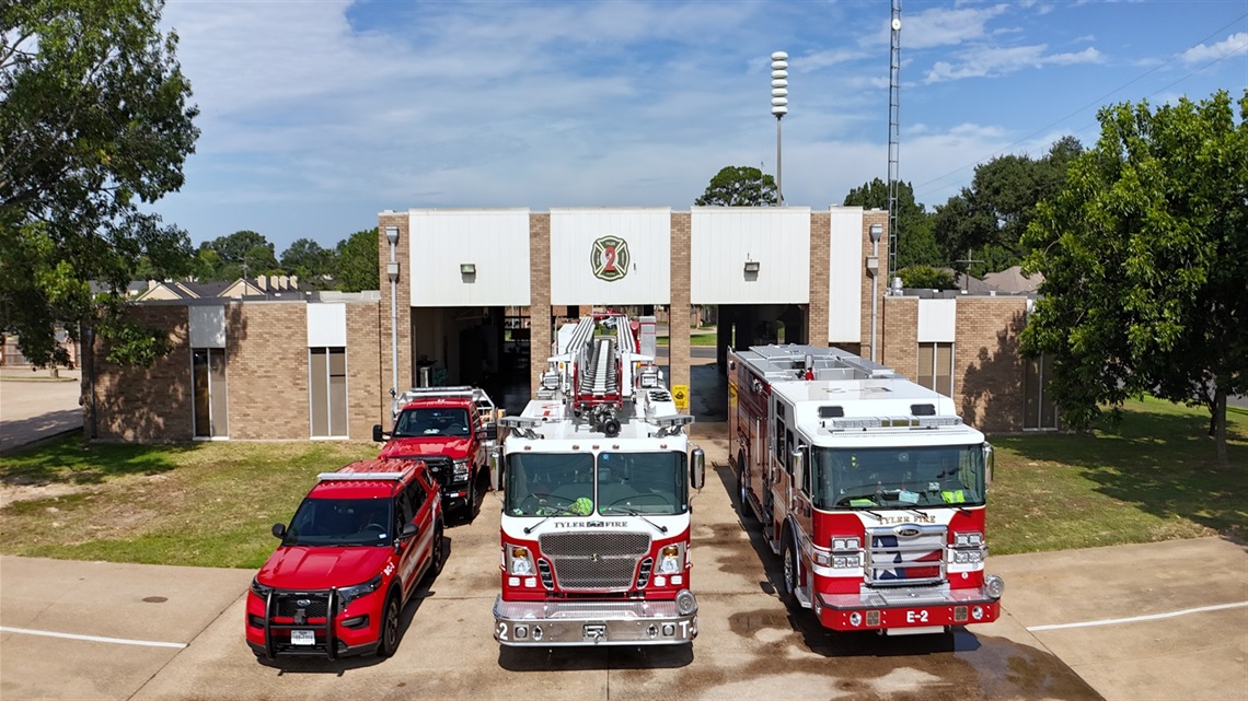A fire station with three fire vehicles parked out front